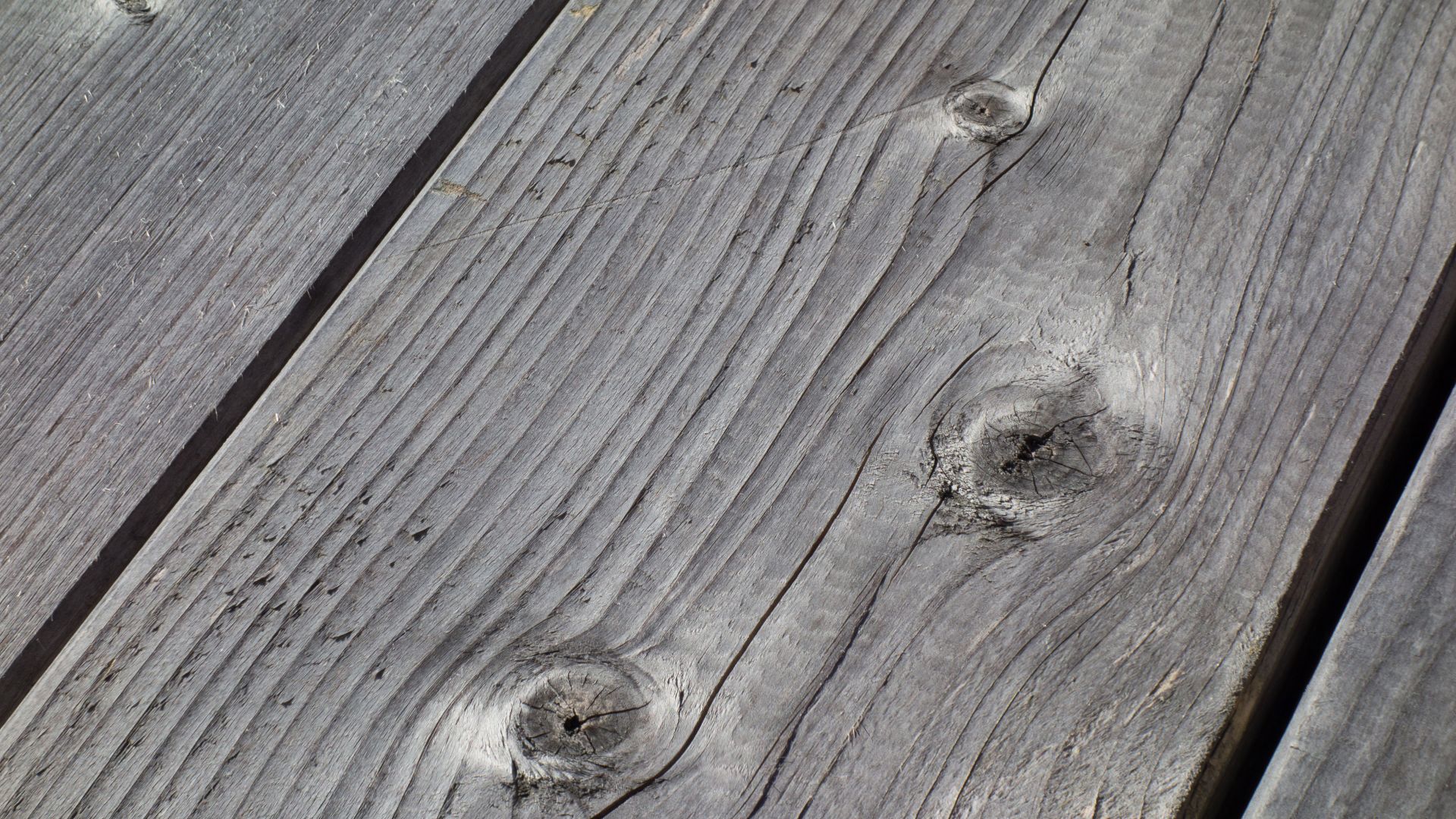 Weatherworn grey silky planks of a plain wooden table outside a fishing hut in Loddebo, Lysekil Municipality, Sweden. The picture is focus stacked from four photos.