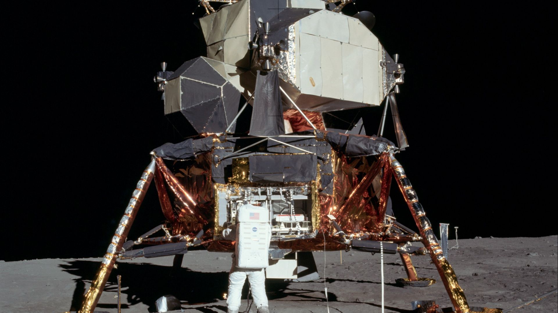 Buzz Aldrin removing the passive seismometer from a compartment in the SEQ bay of the Lunar Lander.