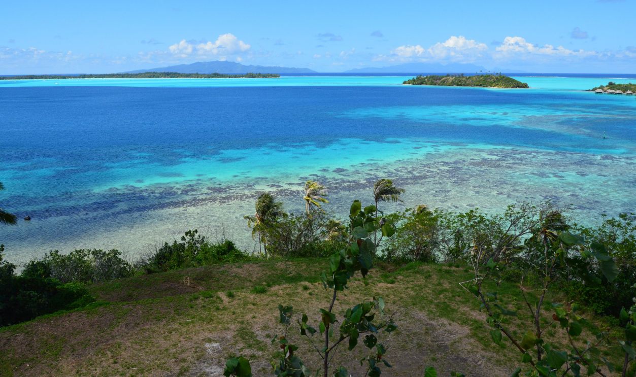 A breathtaking aerial view showcasing a tropical island surrounded by clear turquoise waters and lush greenery