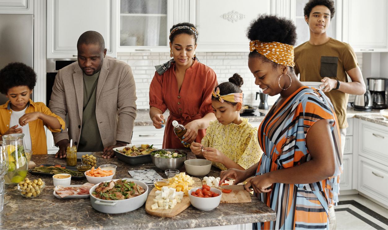 A happy family gathers in the kitchen to prepare a delicious meal together, fostering togetherness