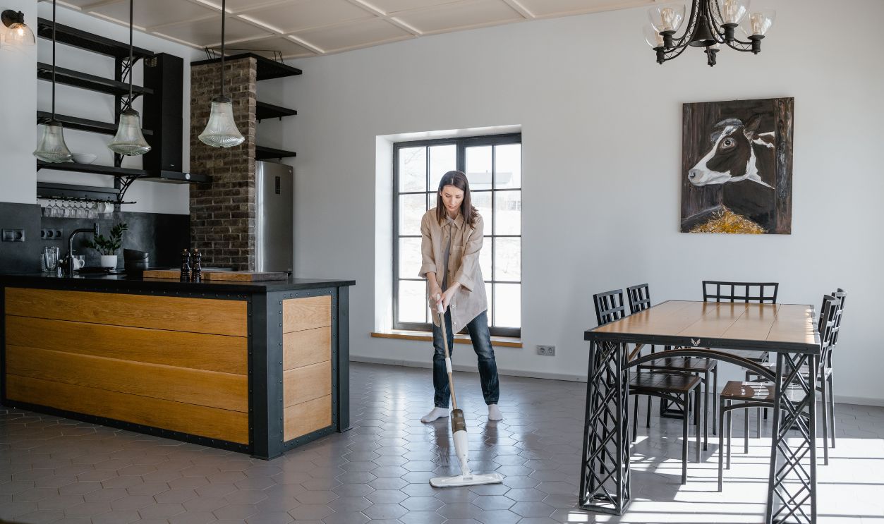 Woman mopping the floor in a contemporary kitchen and dining area