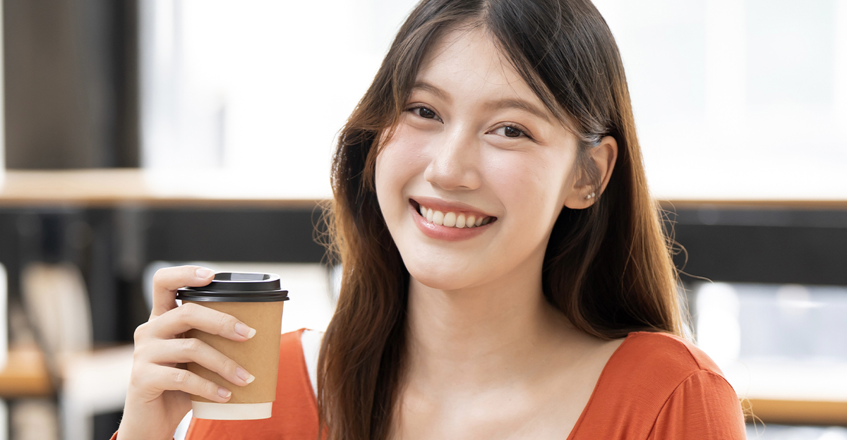 Asian woman holding a cup of coffee.