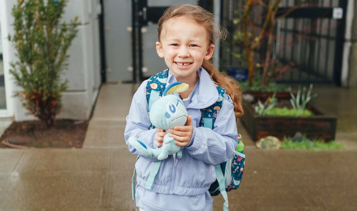 a little girl is holding a stuffed animal