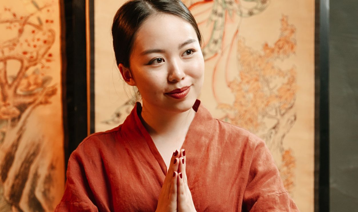 A serene tea ceremony with an Asian woman in a red robe, embodying cultural tradition.
