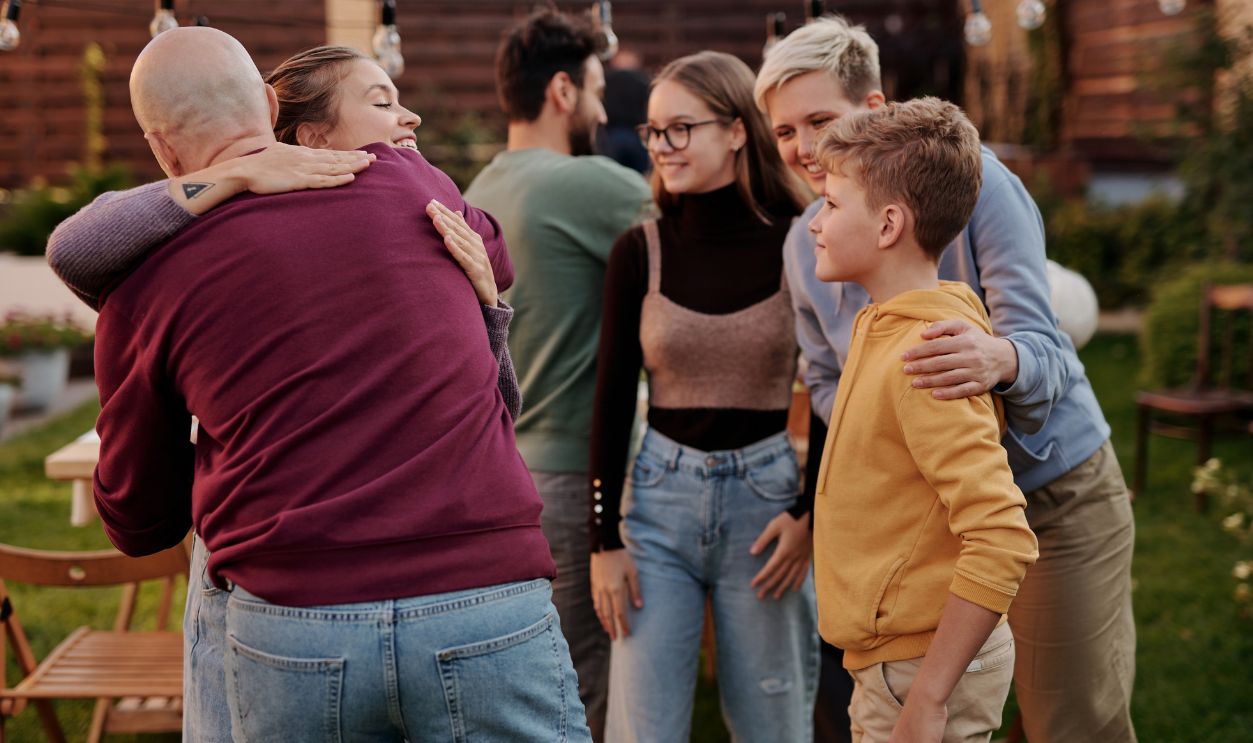 A joyful family gathering outdoors with hugs and smiles, symbolizing love and connection