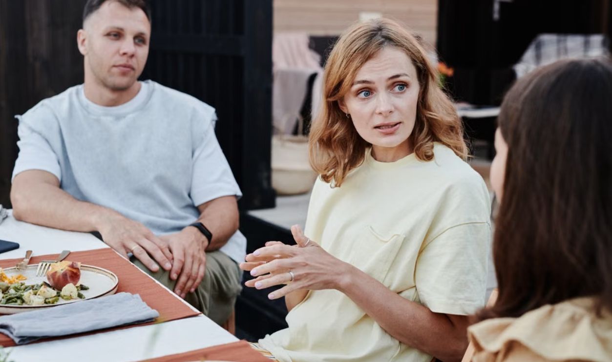 A group of adults enjoying a relaxed outdoor meal together