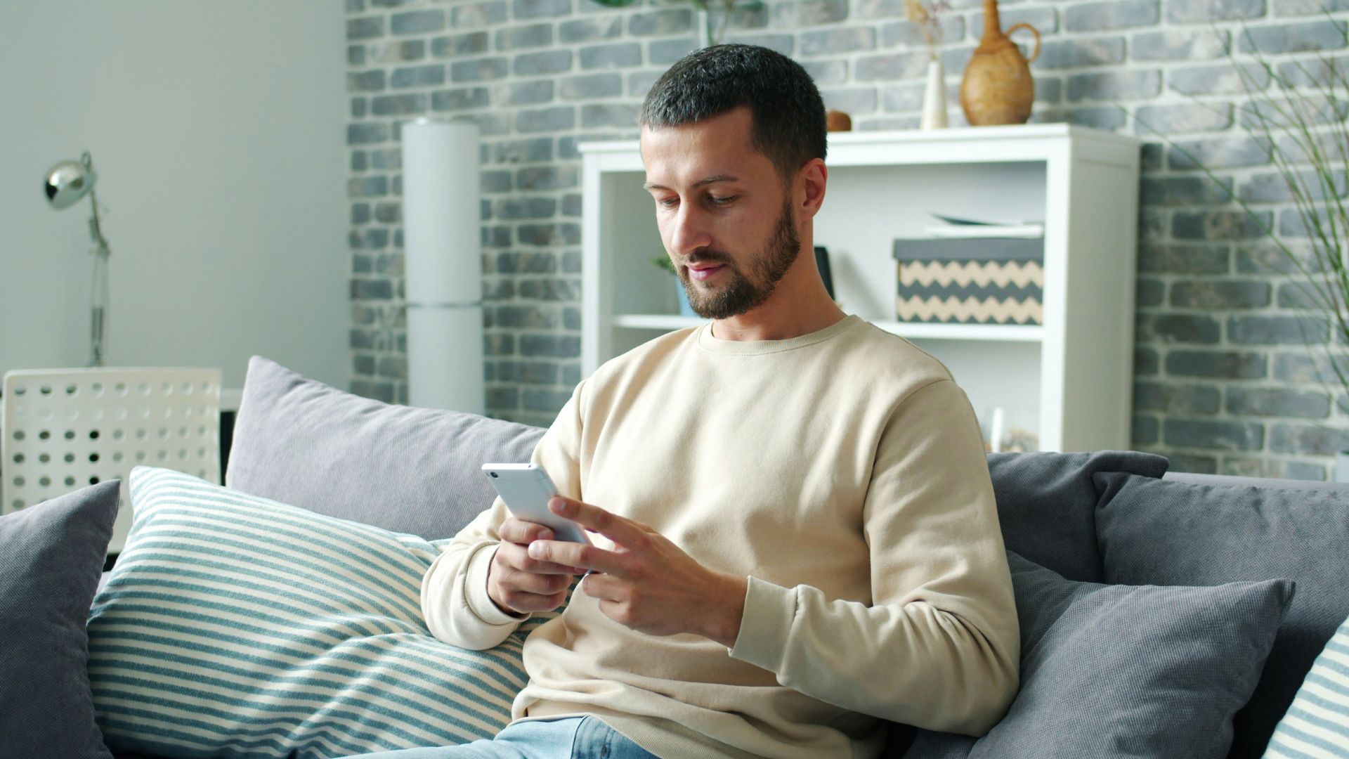 Man sitting on sofa using smartphone