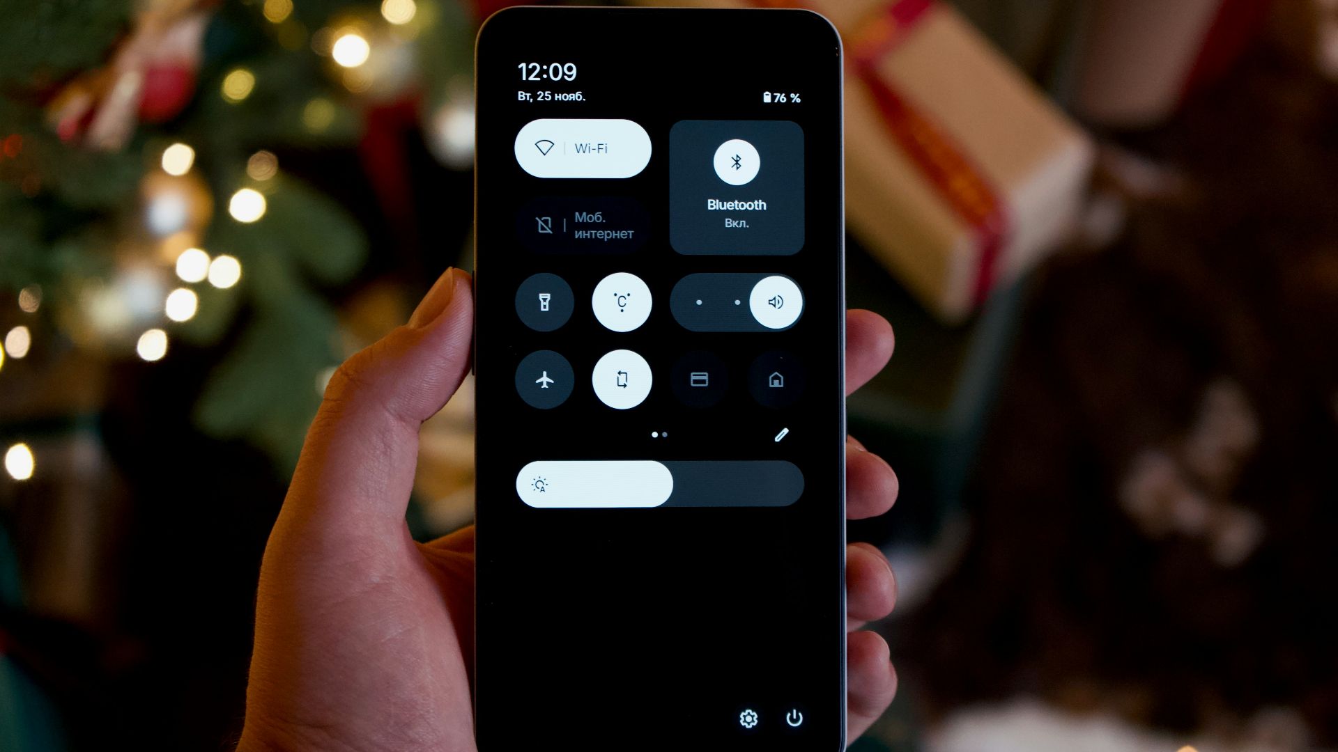 Hand holding a smartphone with a dark interface.
