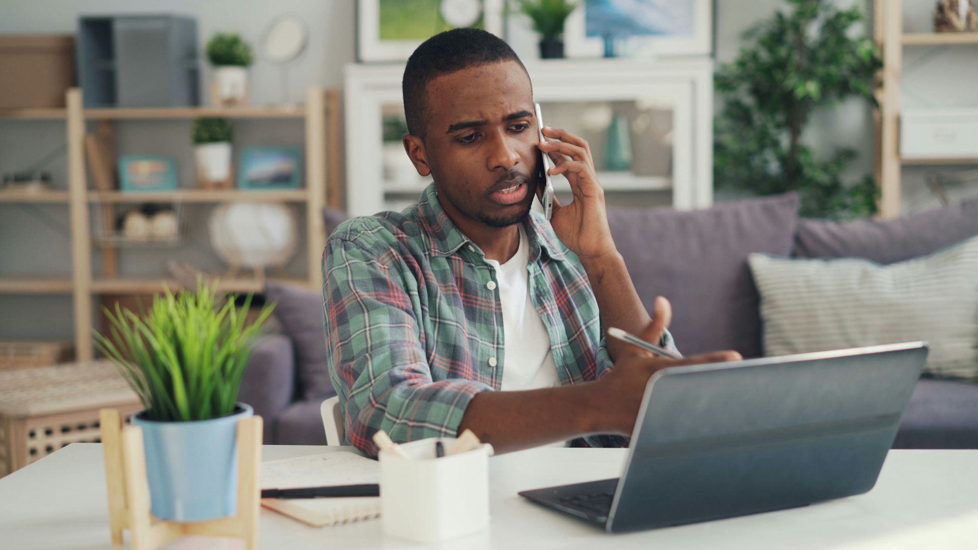 a man sitting at a table talking on a cell phone