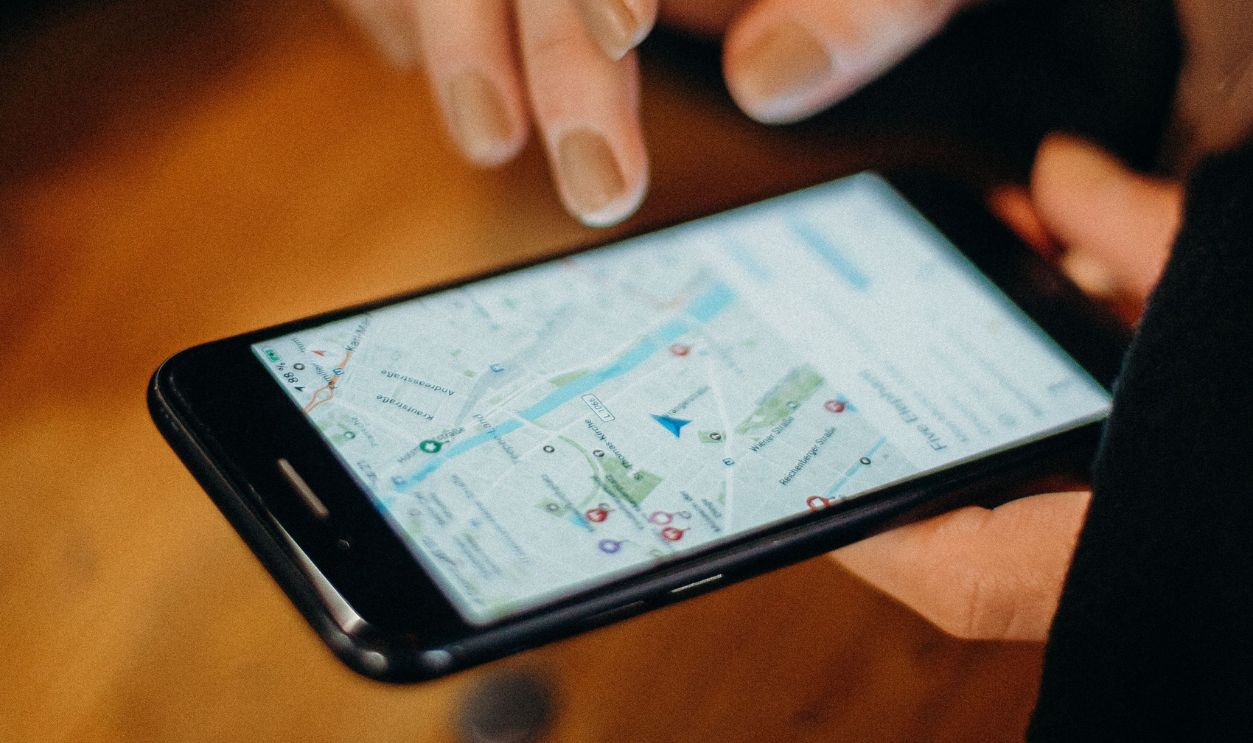 Close-up of a hand using a smartphone displaying a map for navigation.