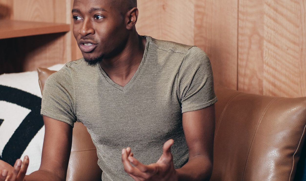 Black man sitting and talking during an office meeting indoors