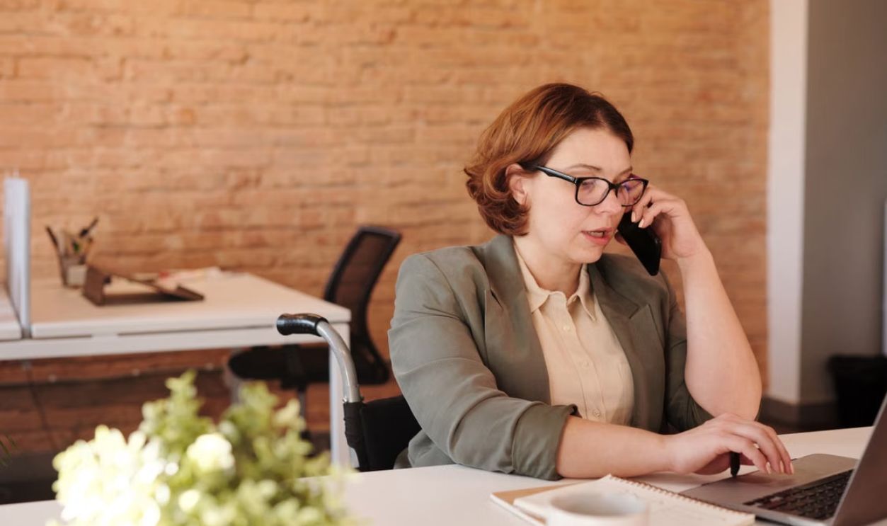 Professional woman in wheelchair working remotely on laptop