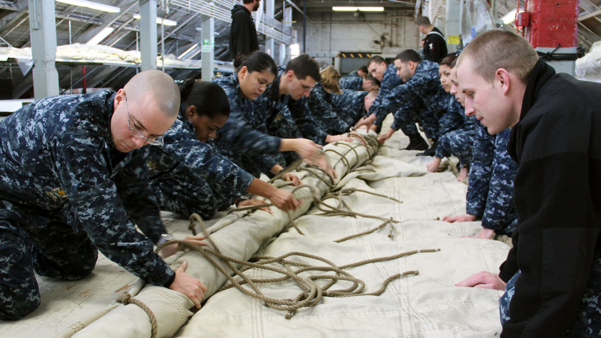 CHARLESTOWN, Mass. (Jan. 20, 2012) Crew members of USS Constitution roll the ship's main topsail in preparation for winter stowage. (U.S. Navy photo by Seaman Michael Achterling/Released)