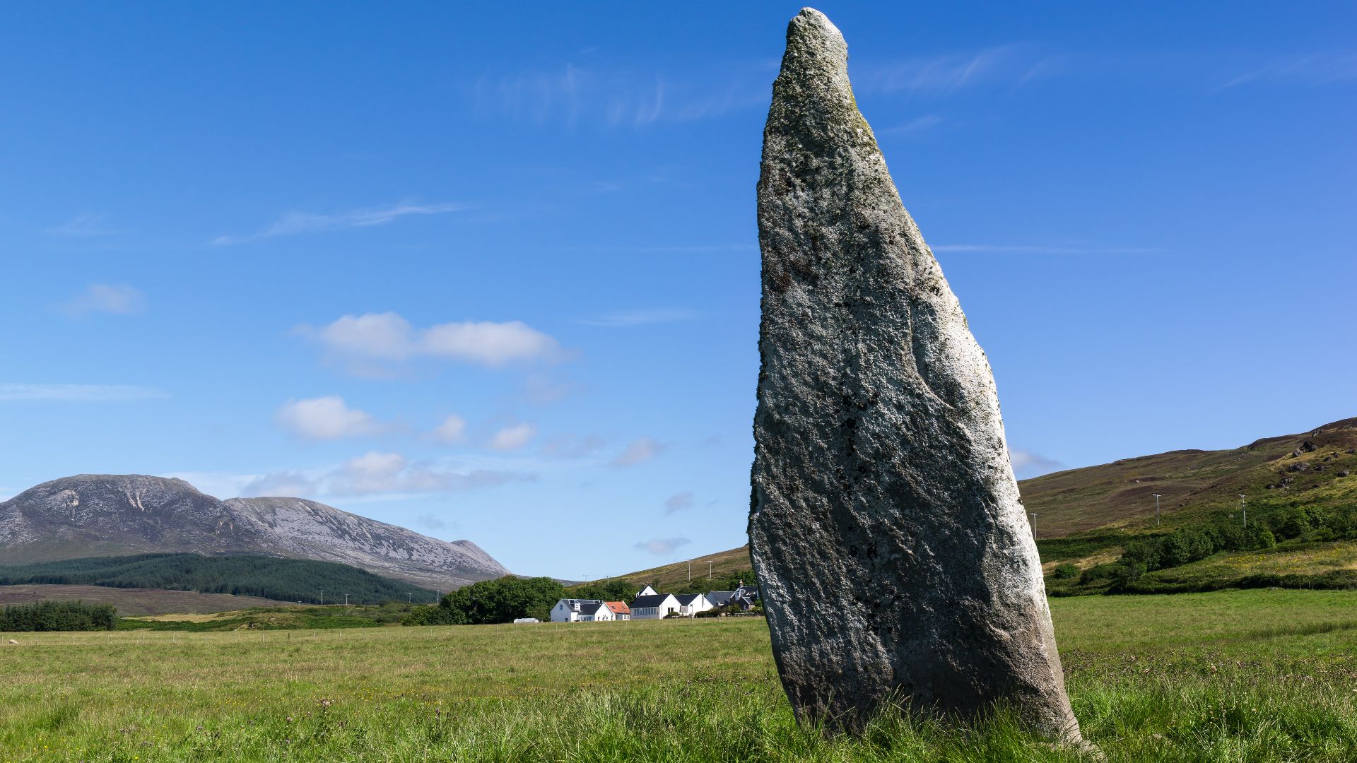 Auchencar standing stone with farm in background, Isle of Arran. Also known as the