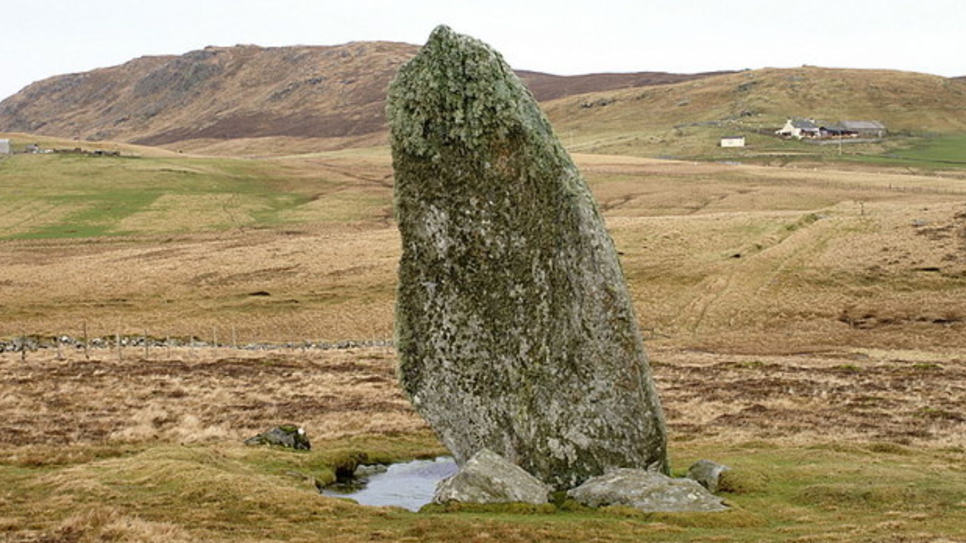 Standing stone at Lund Looking almost due north, towards Erns Hamar at the south end of the Valla Field ridge. The house at the right is Crossbister.