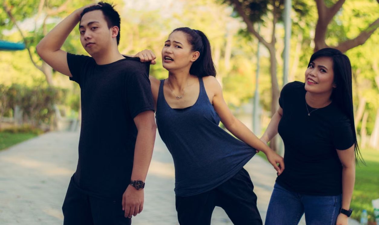 Three friends having fun outdoors in a park, showcasing friendship and happiness.