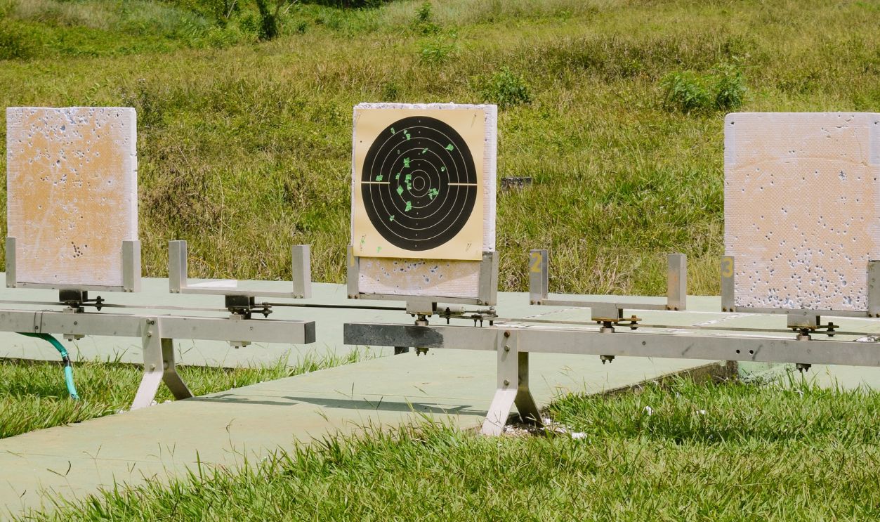 Outdoor shooting range with multiple target boards on a grassy field