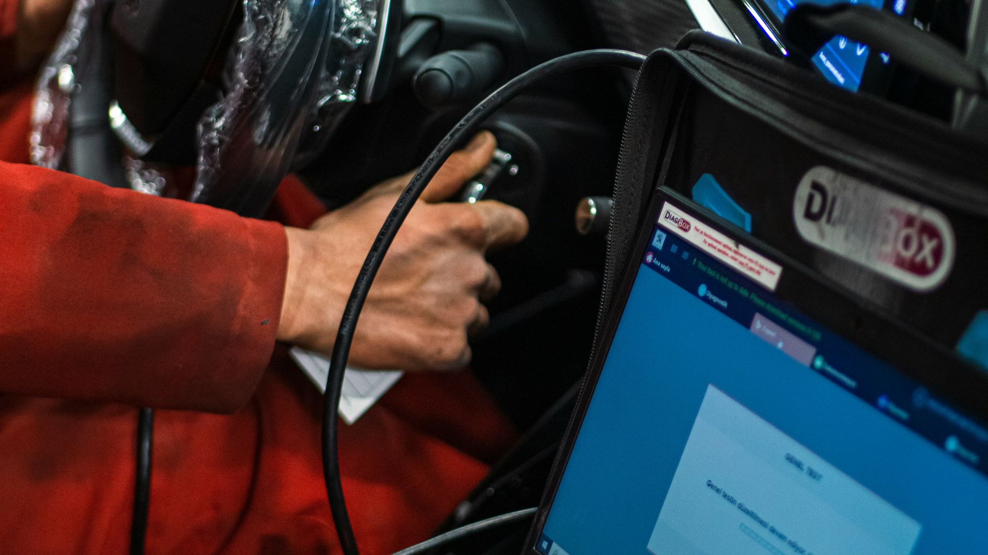 A man sitting in a car using a laptop computer