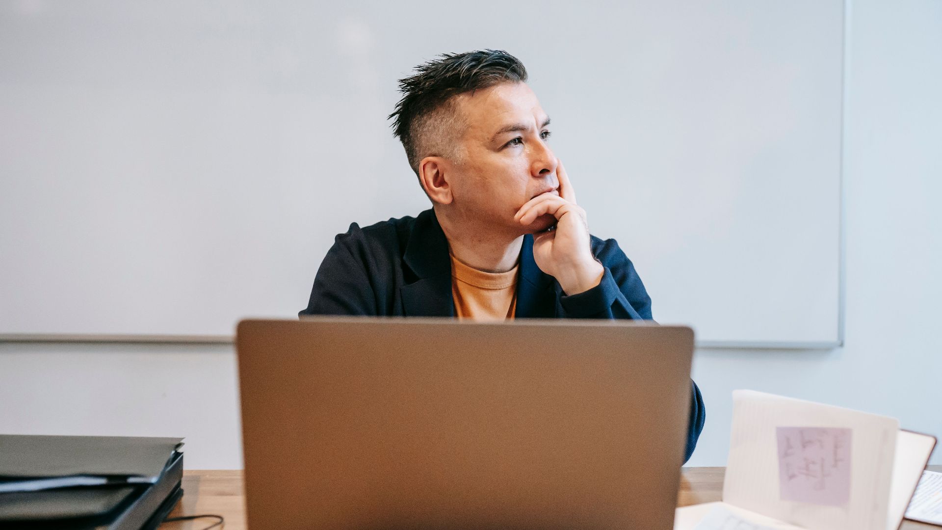 Focused businessman in home office, pondering work thoughts. Perfect for remote work and telecommuting concepts.