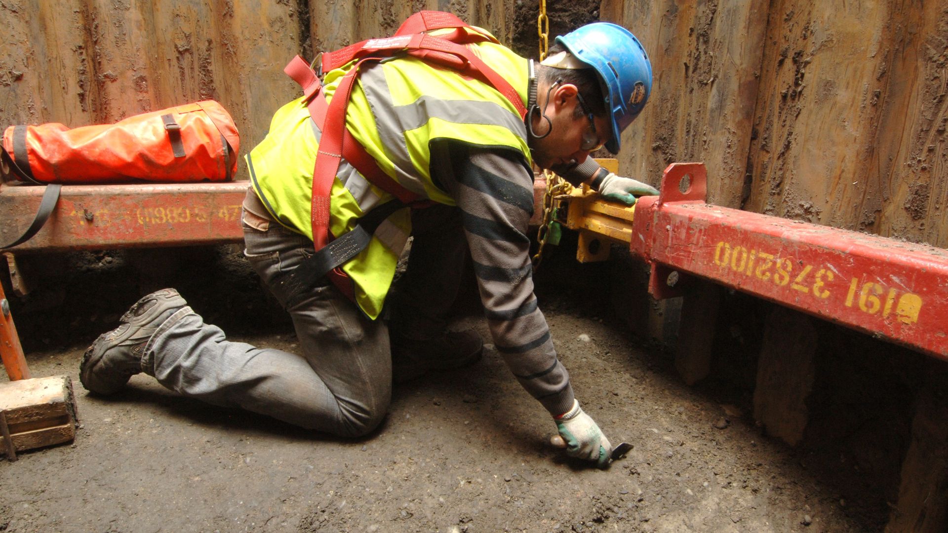 Archaeologist troweling a surface at Liverpool Street Worksite, Liverpool Street (Crossrail XSM10)
