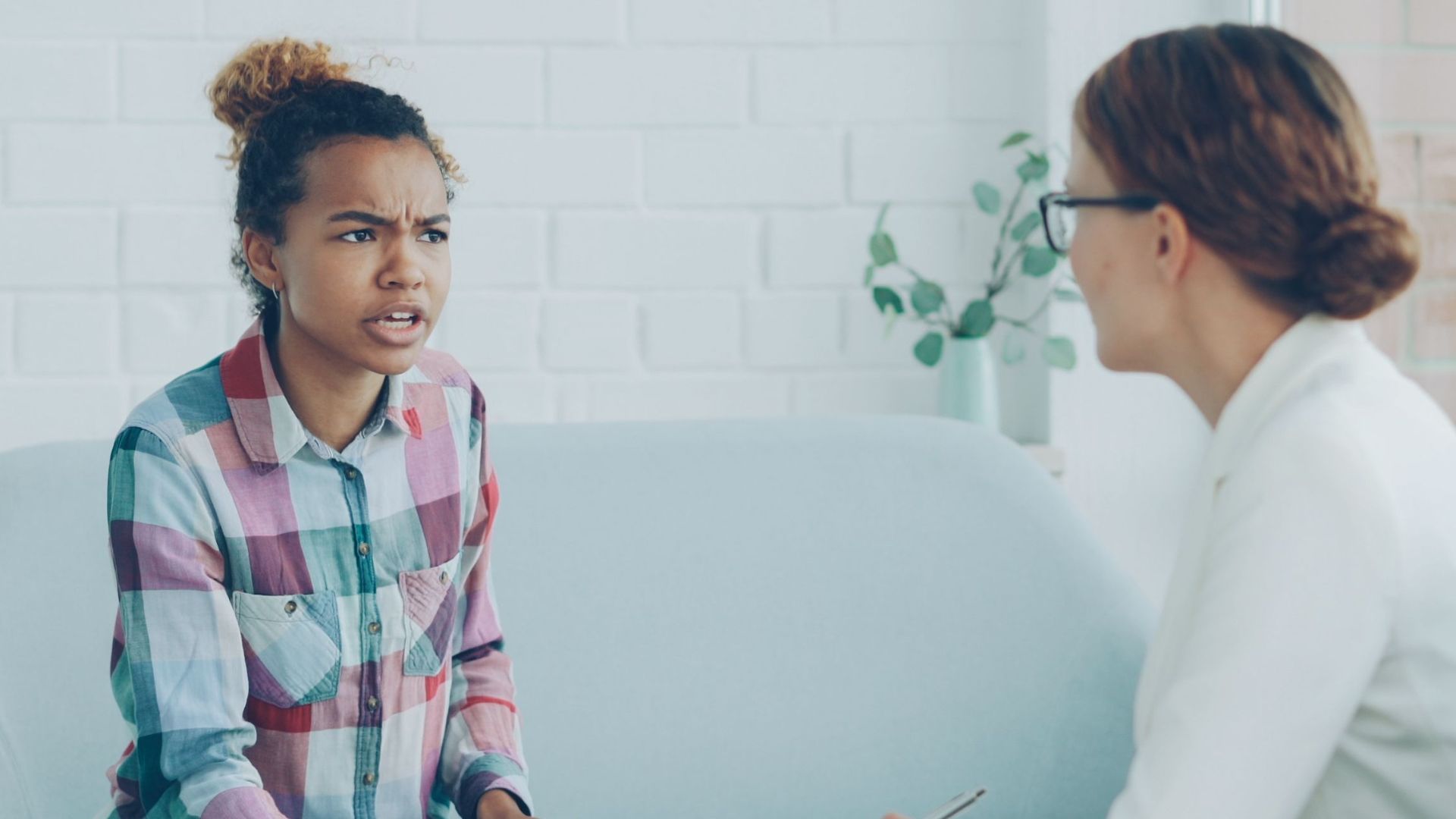 Therapist and patient in conversation during a counseling session indoors.