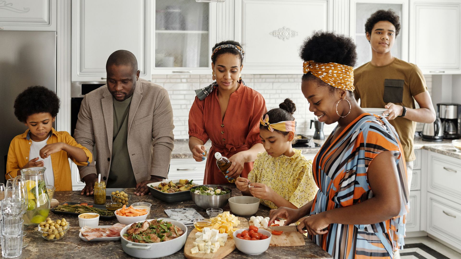 A happy family gathers in the kitchen to prepare a delicious meal together, fostering togetherness and joy.
