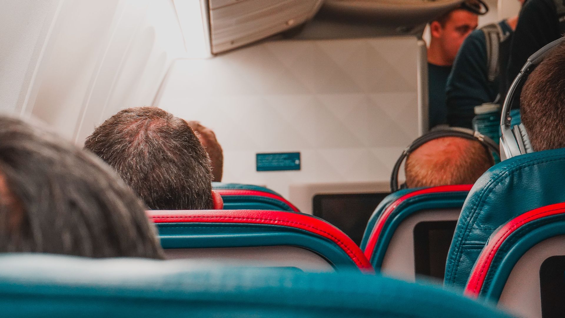 Interior view of an airplane cabin with passengers seated, focusing on seats and layout.