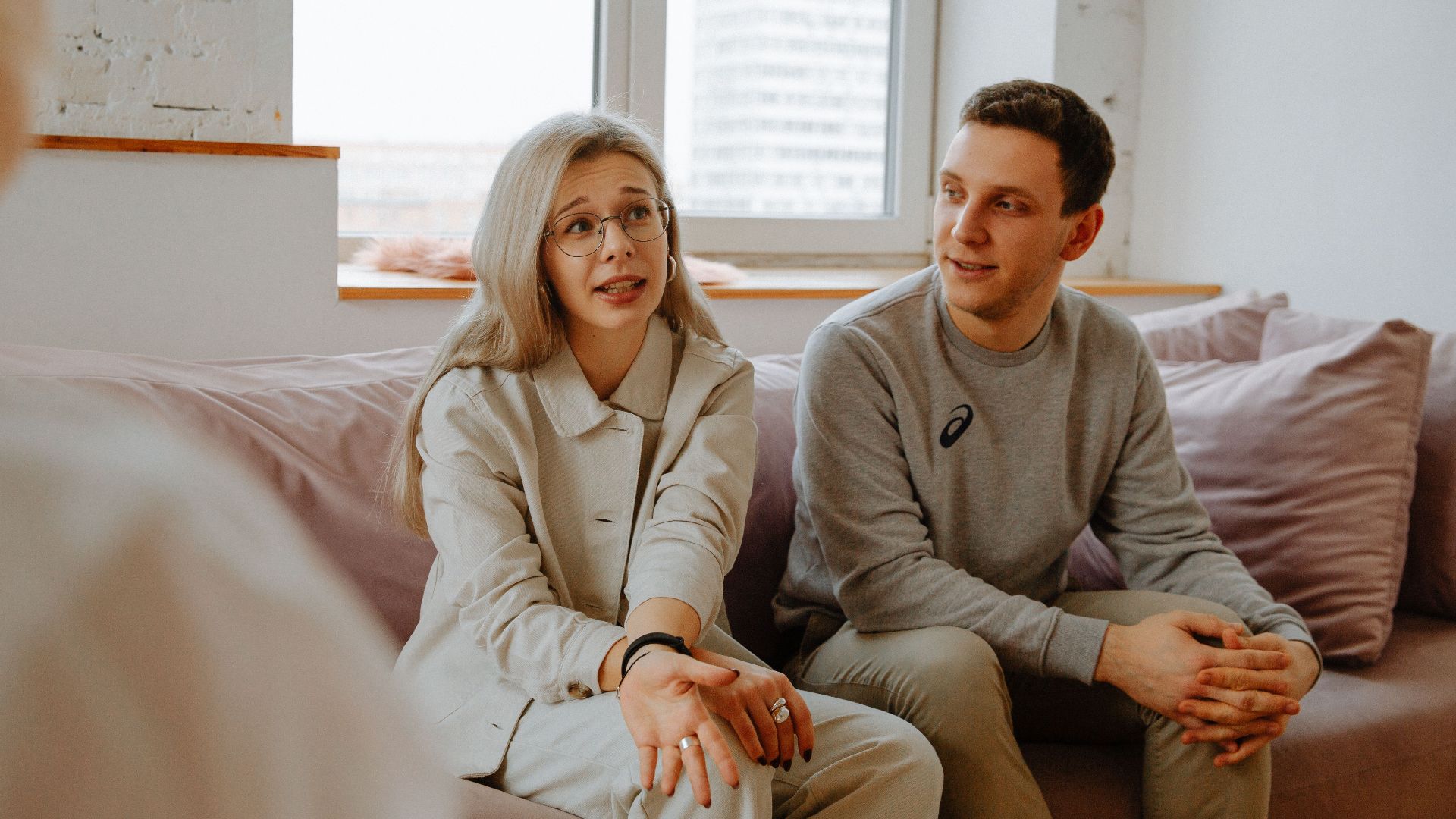 A couple and therapist engaged in a discussion during a therapy session indoors.