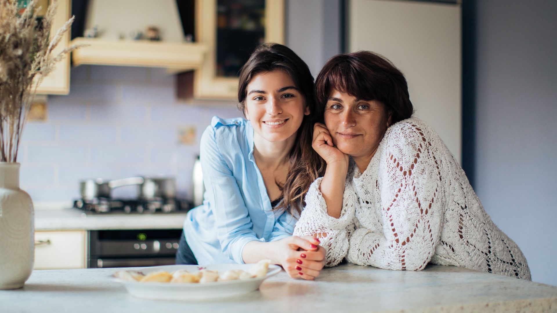 A mother and daughter bonding in the kitchen, smiling and enjoying their time together.