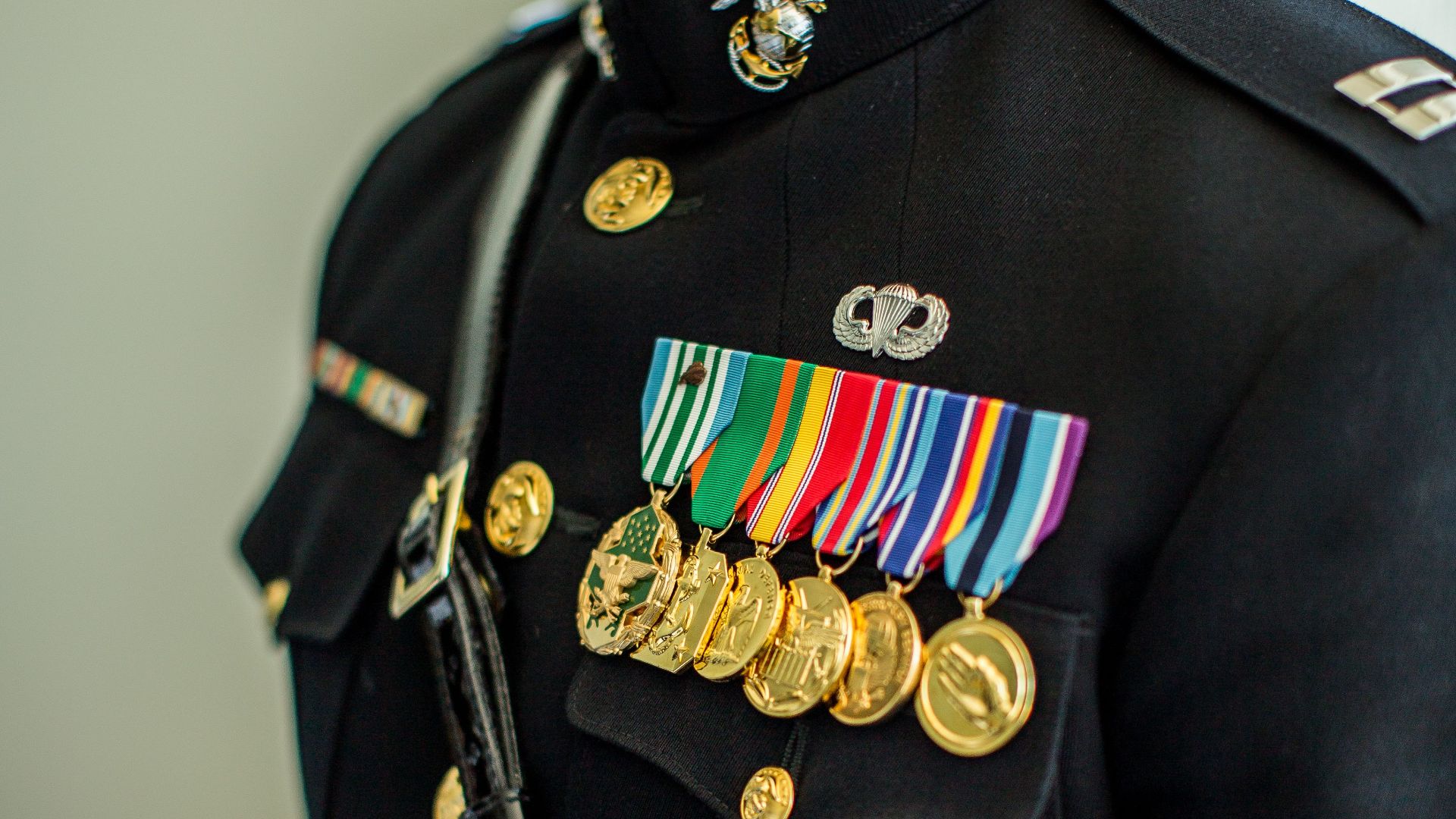 Military officer in dress uniform showcasing various service medals, highlighting dedication and achievement.