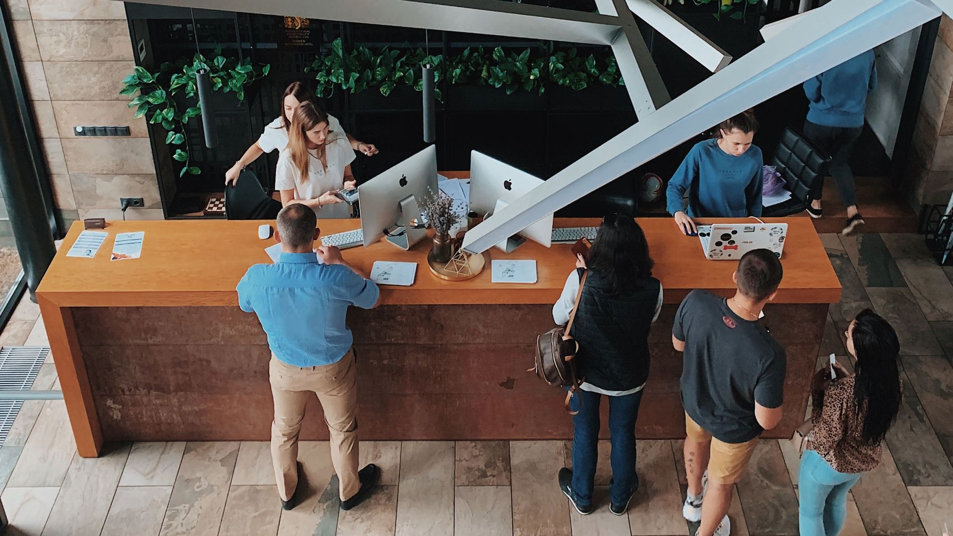 Aerial view of a modern hotel reception with people interacting at the desk in Sosnivka, Ukraine.