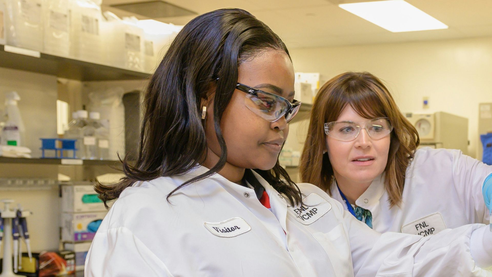 two women in lab coats working in a lab