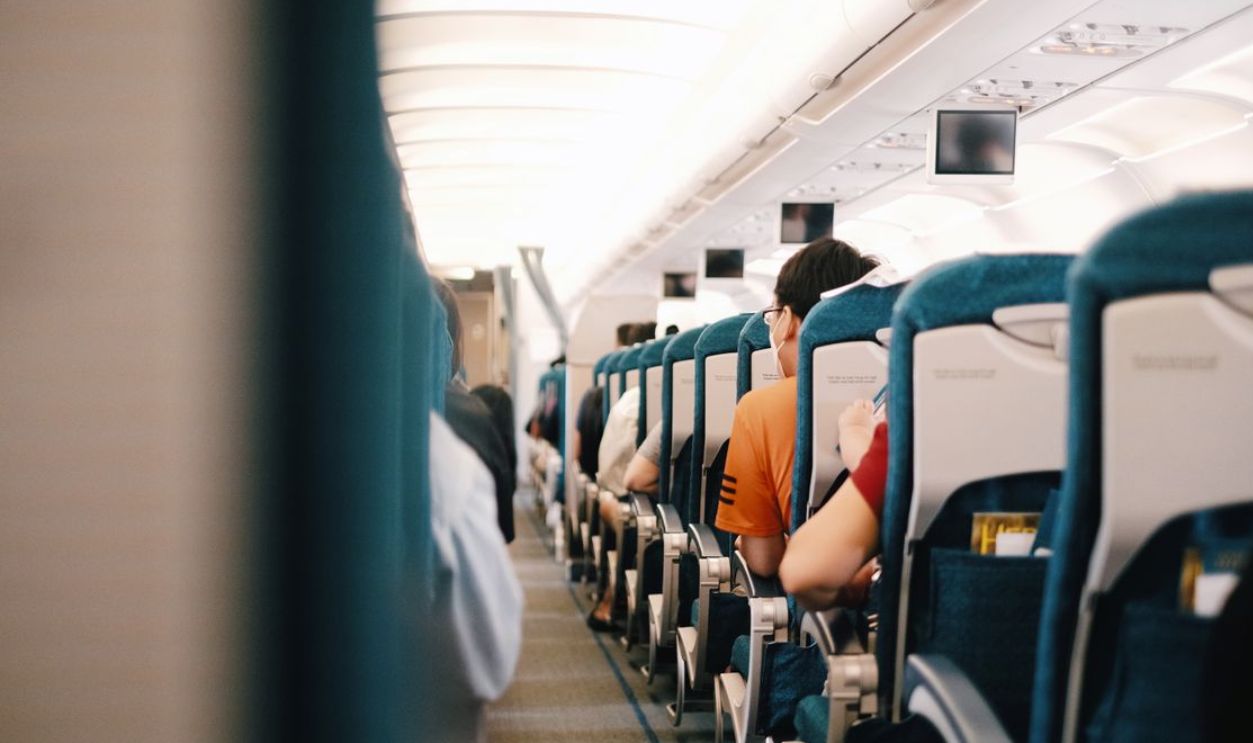 Interior view of airplane cabin showing passengers seated during a flight