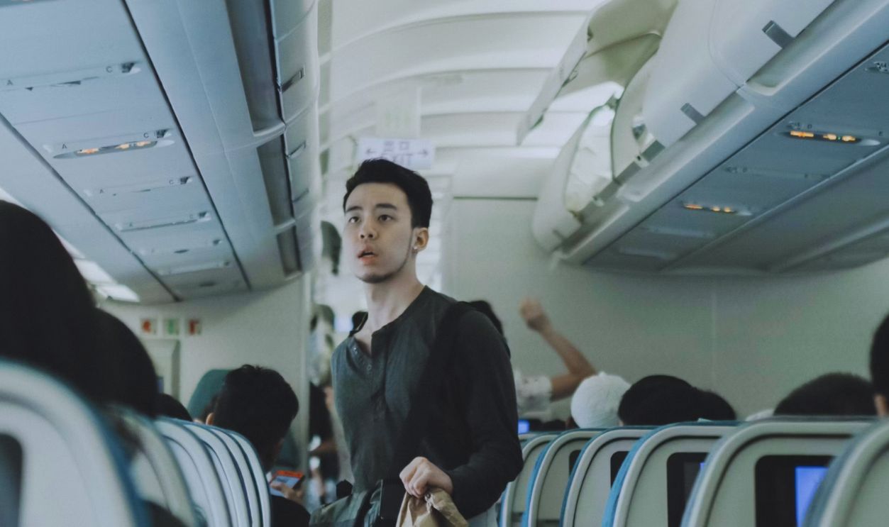 man holding bags inside plane