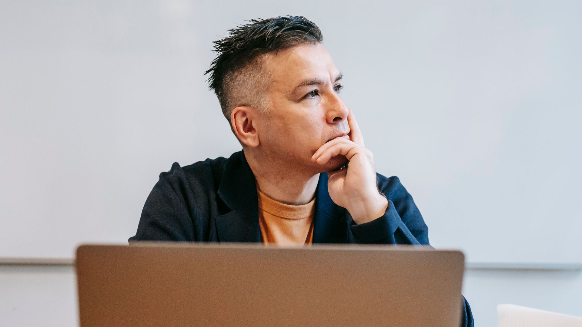 Focused businessman in home office, pondering work thoughts. Perfect for remote work and telecommuting concepts.