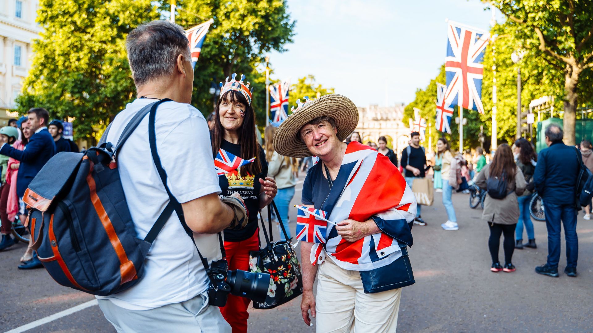 Joyful street scene in Central London with people celebrating under Union Jack flags, capturing vibrant city life.