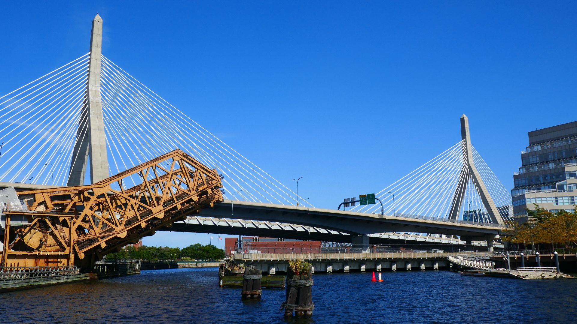 Drawbridge carrying commuter trains opens to allow boats to pass underneath, Charles River, Boston.  Zakim Bridge is at rear.