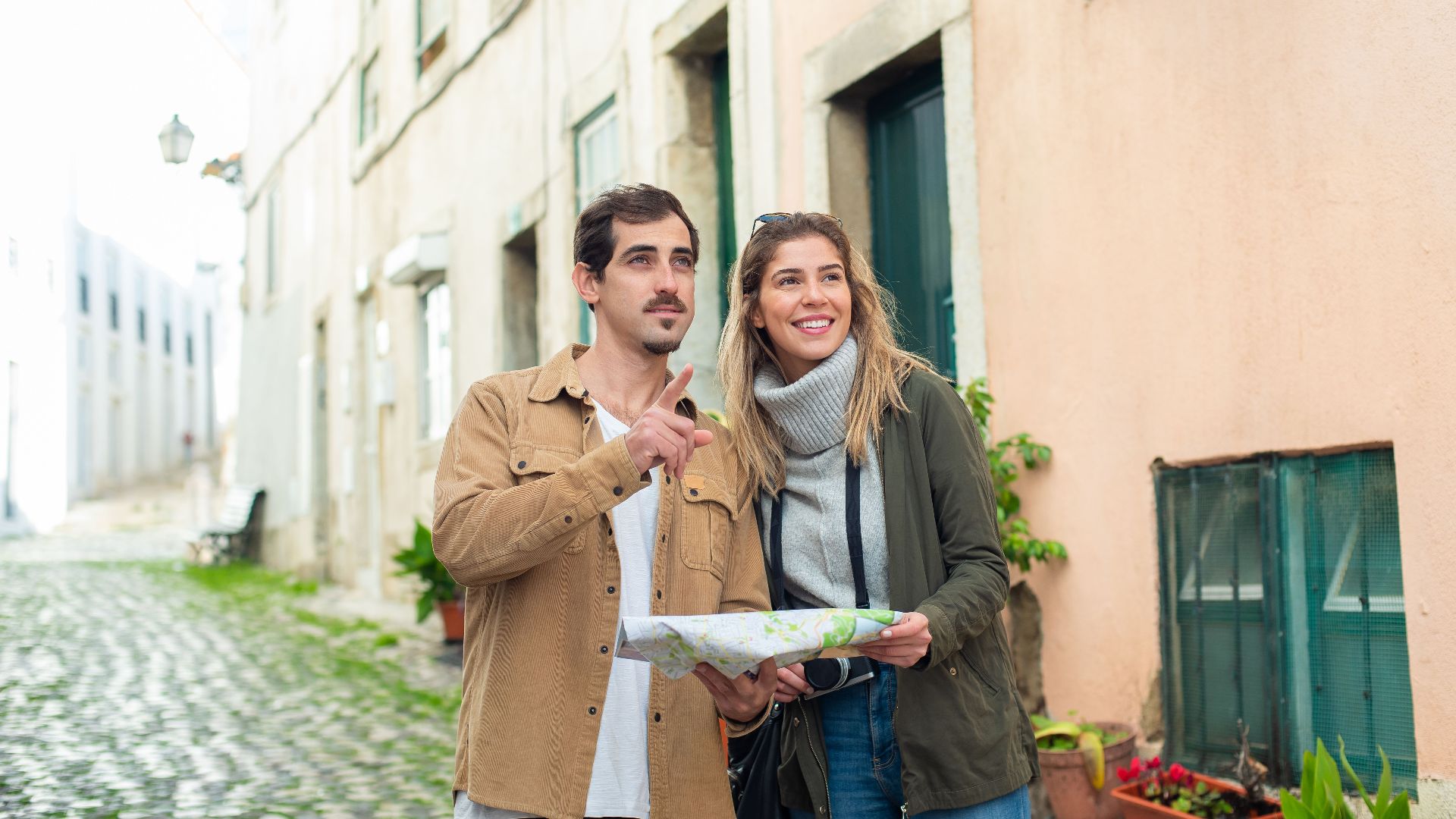 Happy couple exploring a historic city using a map, enjoying a travel adventure together.