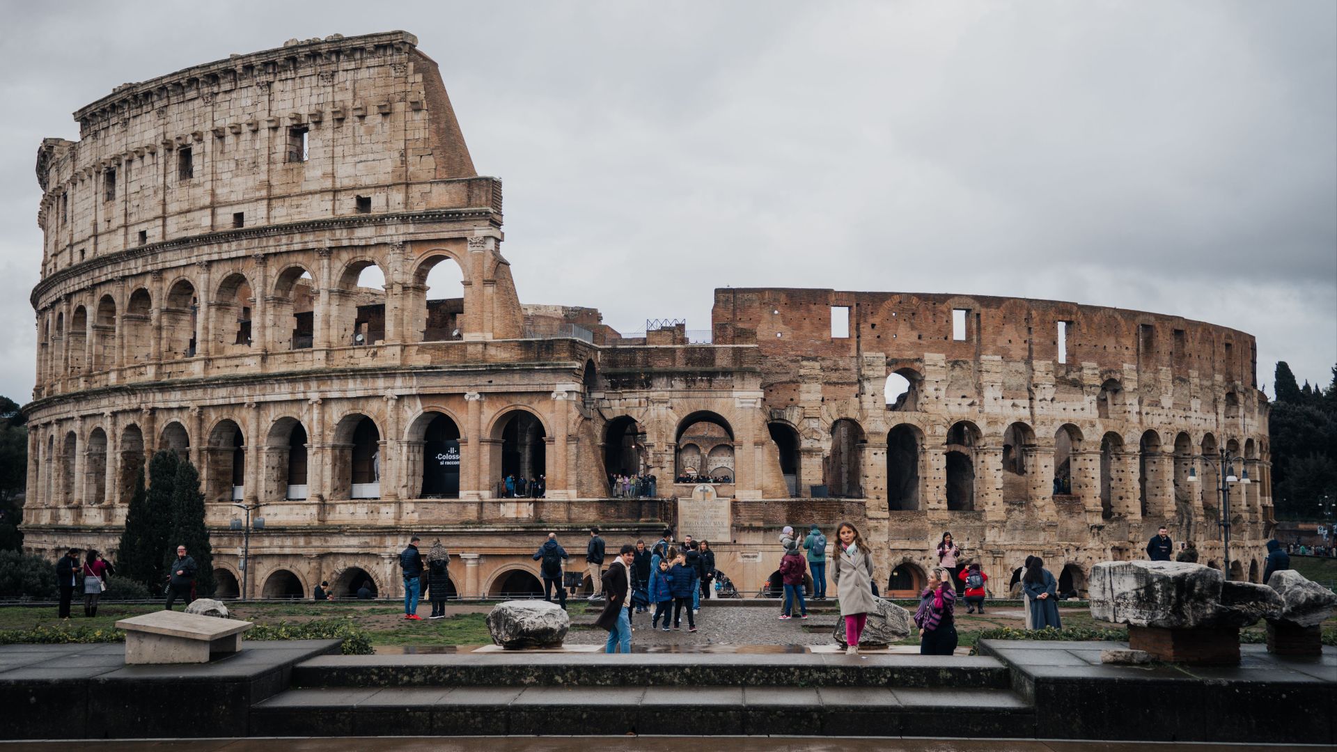 Tourists explore the historic Colosseum in Rome, a symbol of ancient architecture.