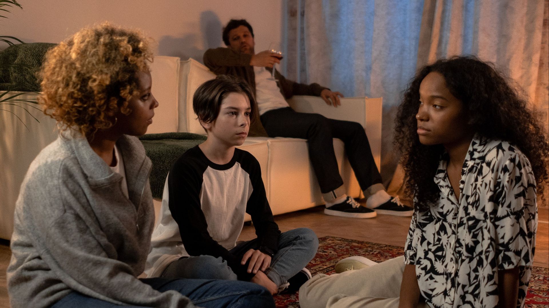 A diverse family engaged in a serious discussion in their cozy living room.