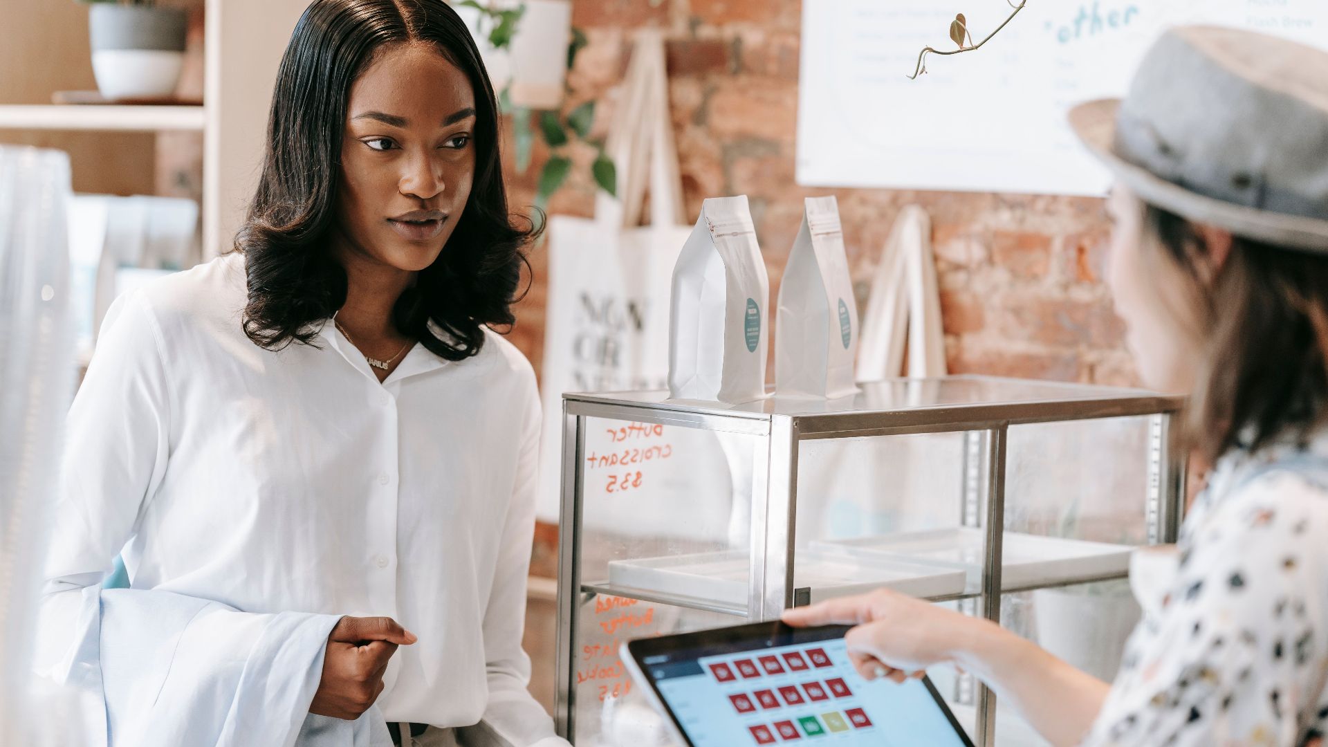 A customer interacts with a barista at a trendy coffee shop counter, showcasing modern retail service.