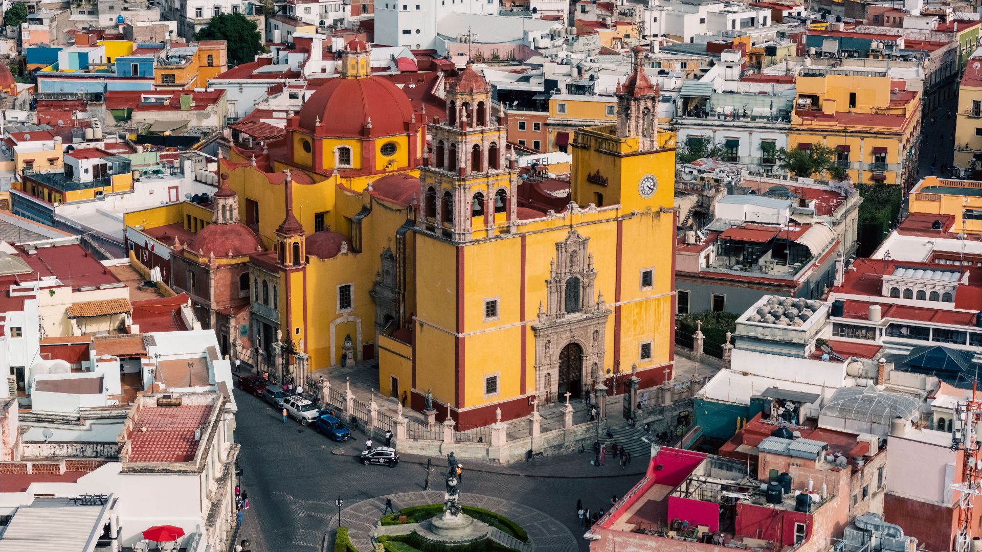 A colorful aerial view of the historic cityscape of Guanajuato featuring notable architecture.