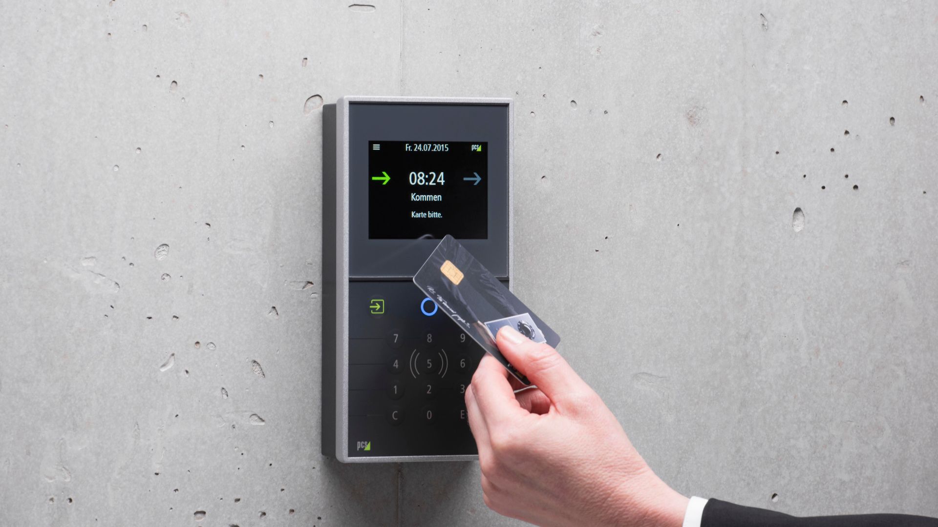 A businessman uses a secure card reader access system against a concrete wall.
