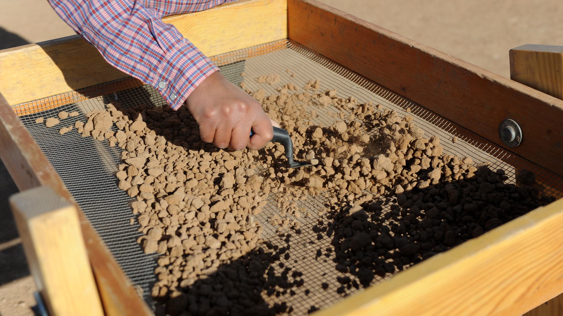 Rachelle Robinson, archaeological field technician, screens dirt for artifacts at Archaeological Site 419, Luke Air Force Base, April 12. Dirt from the digging is screened and scanned to find small artifacts that may be missed by the human eye.