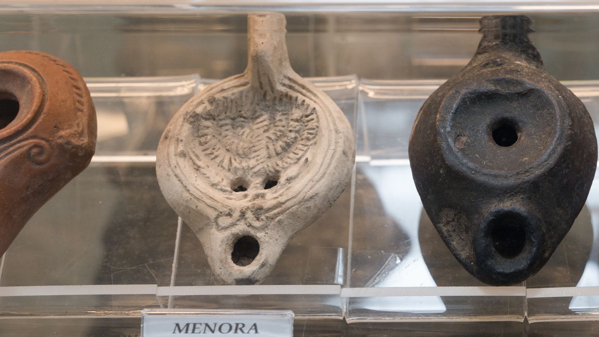 Oil lamps. Oil lamp with the motif of the Jewish temple candelabrum, menorah. Roman terracotta, 2nd century AD. Museum Humanum, Fratres.