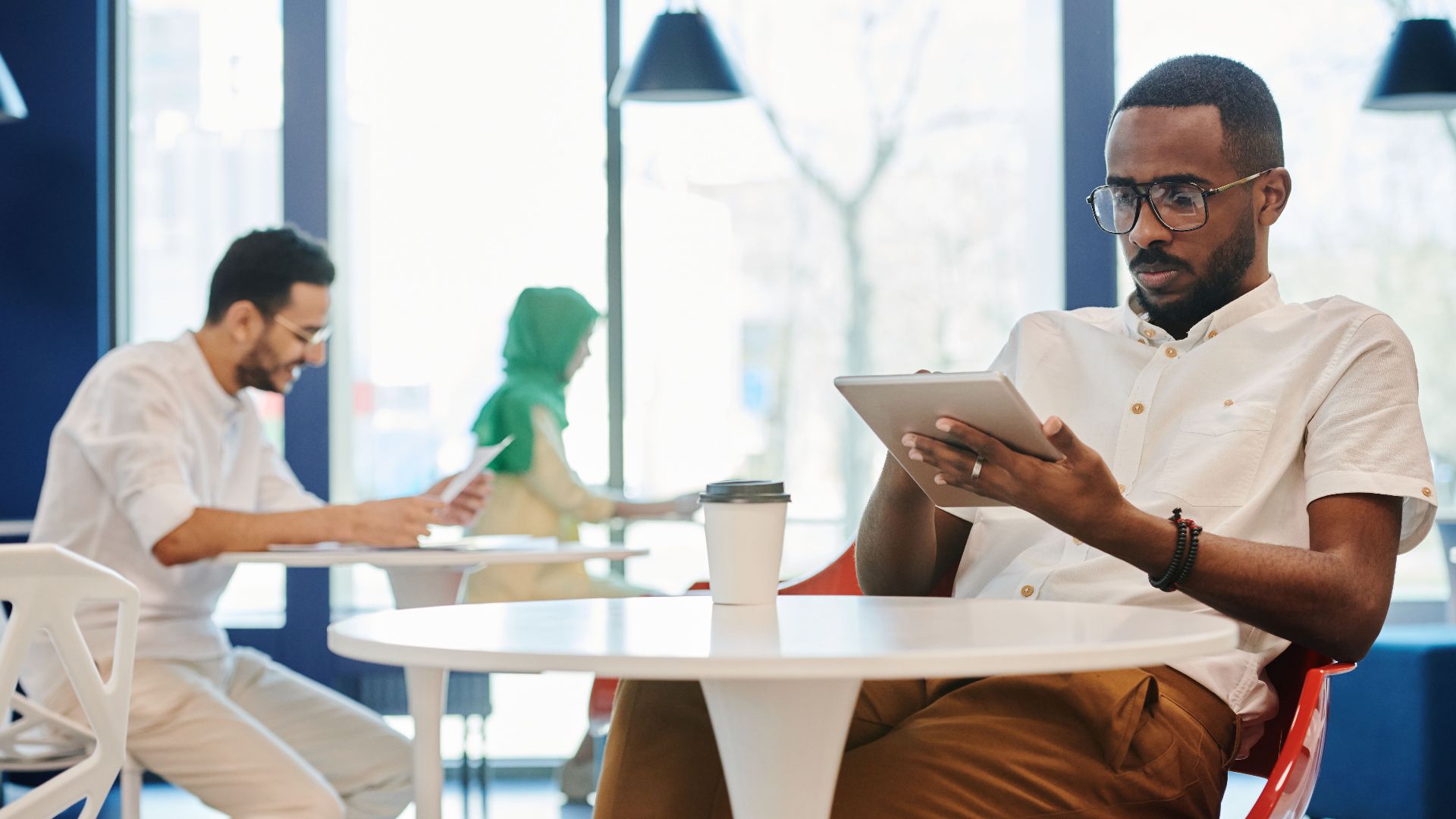 Two professionals using tablets in a contemporary office setting. Collaborative and digital work environment.