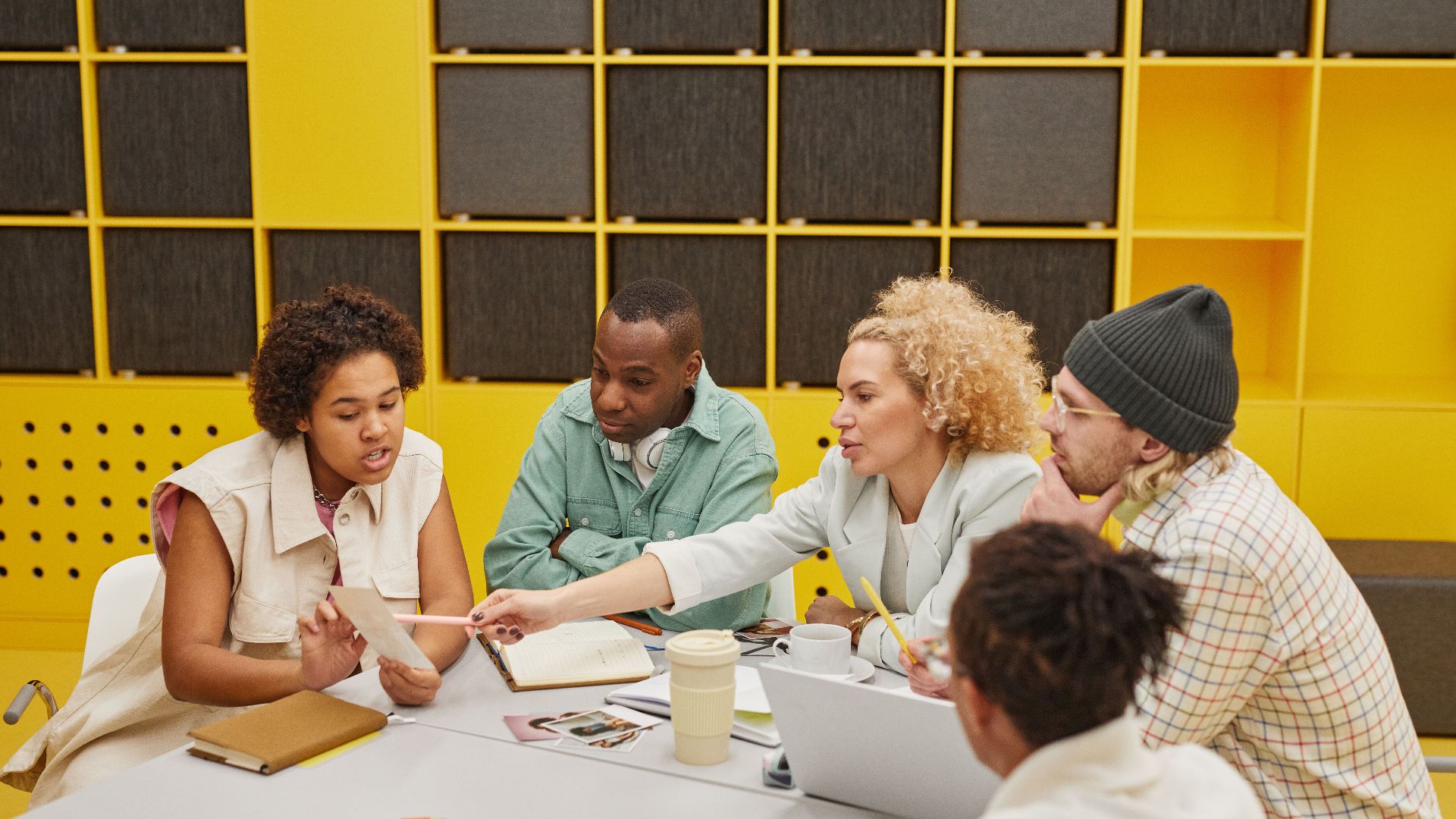 A group of coworkers engaged in a collaborative meeting at a modern office table.
