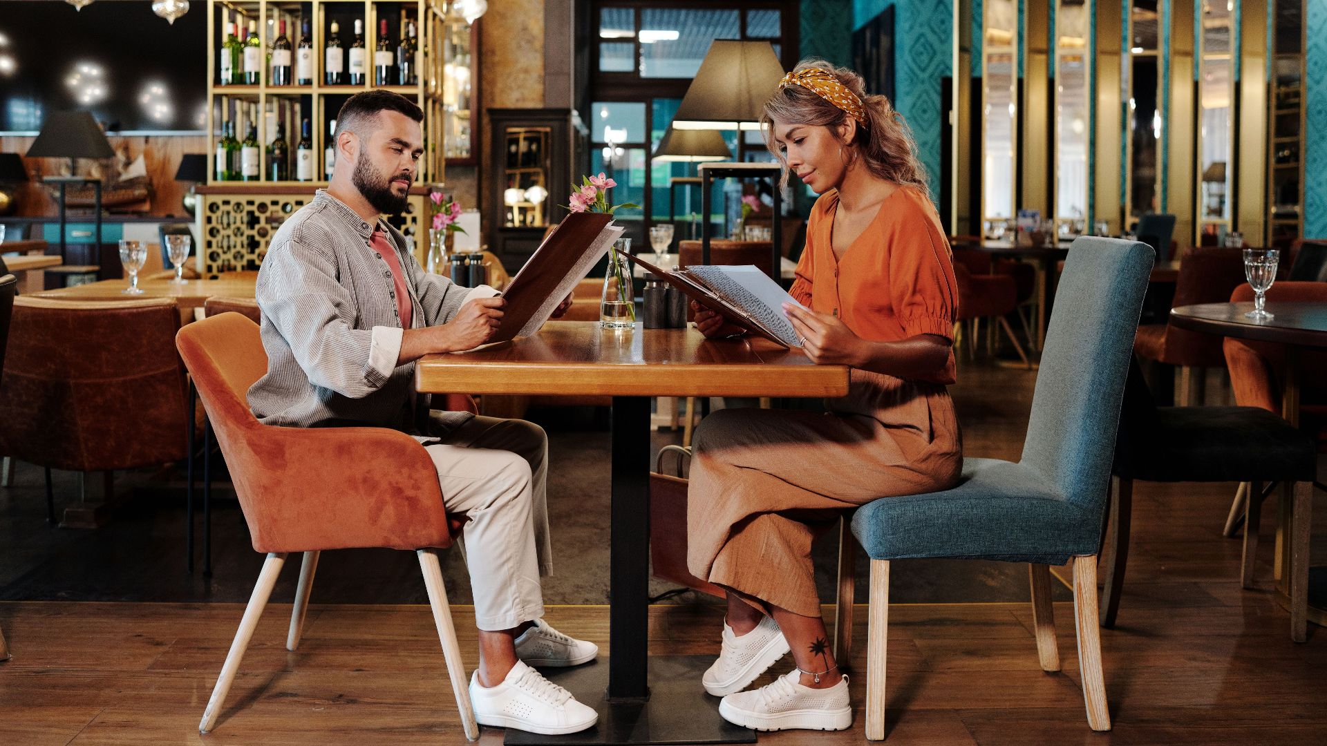 Couple sitting together at a stylish restaurant reviewing the menu, creating a warm and inviting atmosphere.