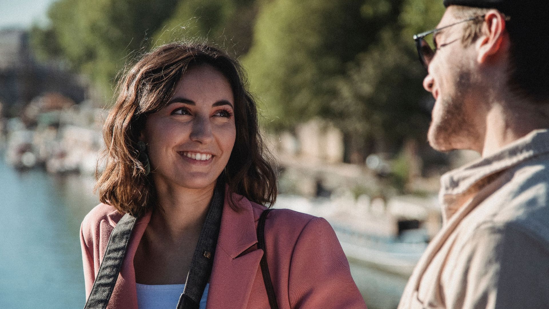 A cheerful couple enjoying a sunny day by the water, sharing smiles and conversations.