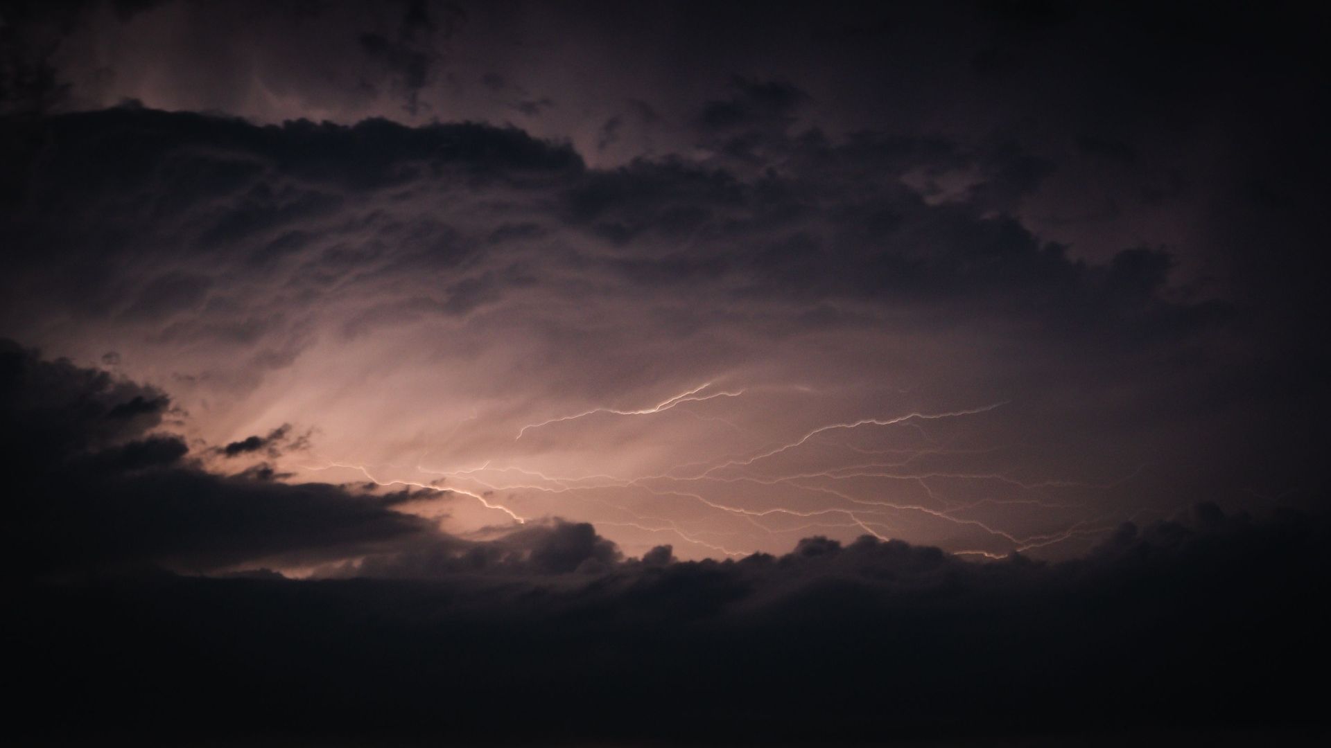 Striking lightning illuminating dark storm clouds in a dramatic night sky